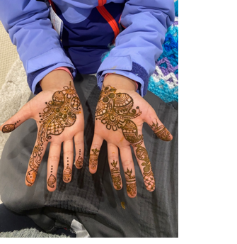 A person with henna on their hands

Description automatically generated