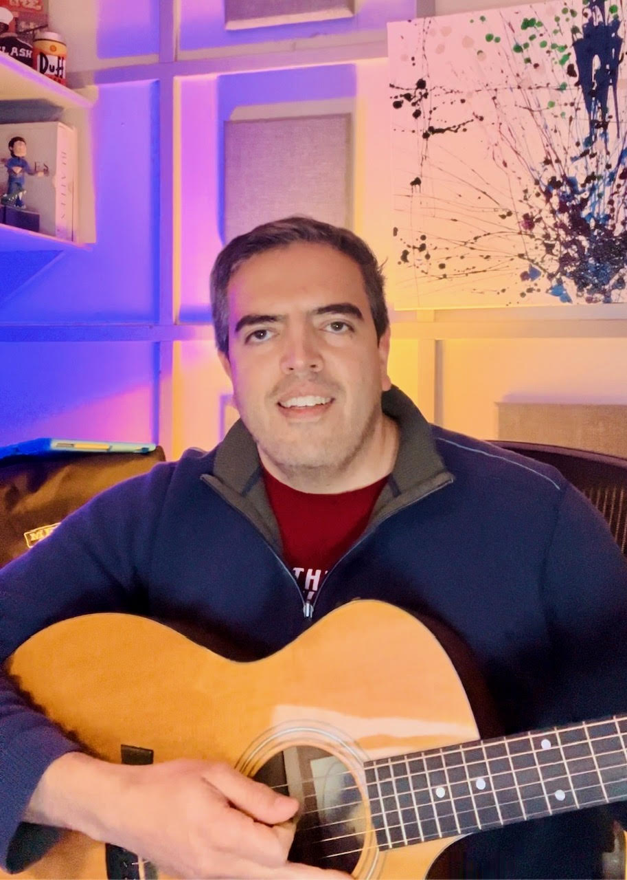 A person holding a guitar

Description automatically generated