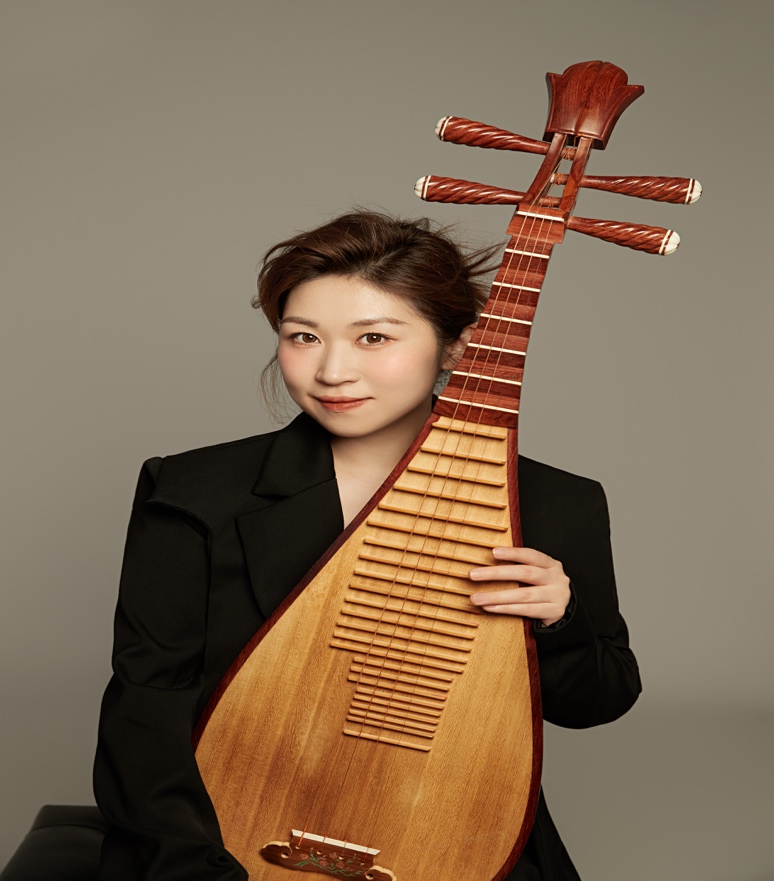 A person holding a stringed instrument

Description automatically generated